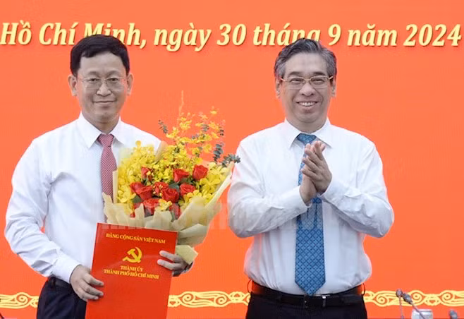 Phó Bí thư Thành ủy TPHCM Nguyễn Phước Lộc trao quyết định cho ông Trần Quốc Trung. Ảnh: Thành ủy TPHCM