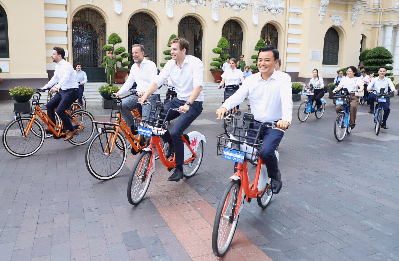 Lãnh đạo hai thành phố cùng các đại biểu đạp xe trên đường phố TPHCM sau buổi làm việc. Ảnh: Ngô Tùng