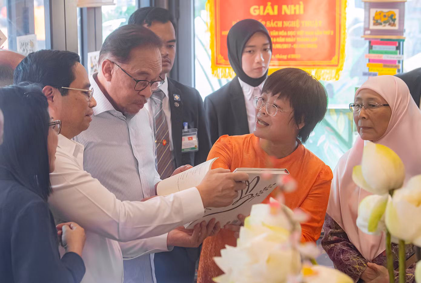 Hai Thủ tướng cùng hai Phu nhân nghe giới thiệu về sách. (Ảnh: Thái Nam)