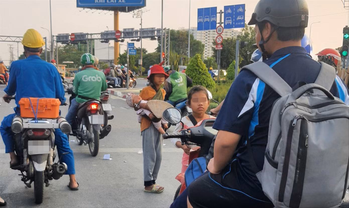 Các bé gái xin tiền người đi đường tại giao lộ Võ Văn Kiệt - An Dương Vương. Ảnh: Hoàng Thuận