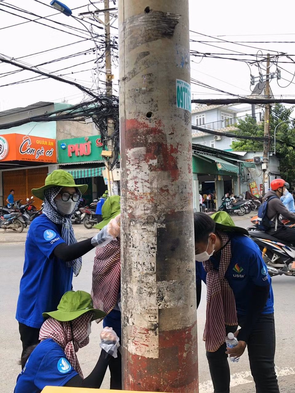 Các chiến sĩ 'Mùa Hè Xanh' đang vệ sinh các cột điện trước khi tô điểm cho chúng.