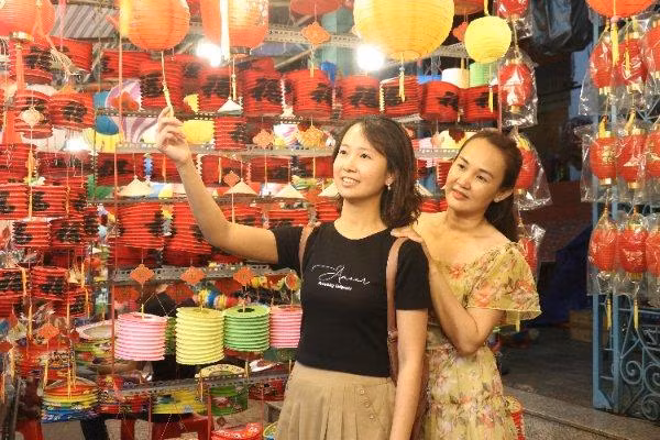 Các bạn trẻ thích thú tạo dáng chụp ảnh cùng lồng đèn.