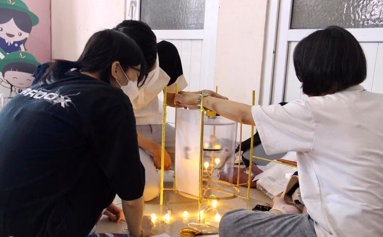 Các thành viên CLB Bé Khỏe Bé Ngoan đang chuẩn bị những chiếc lồng đèn xinh xắn gửi tặng các bệnh nhi.
