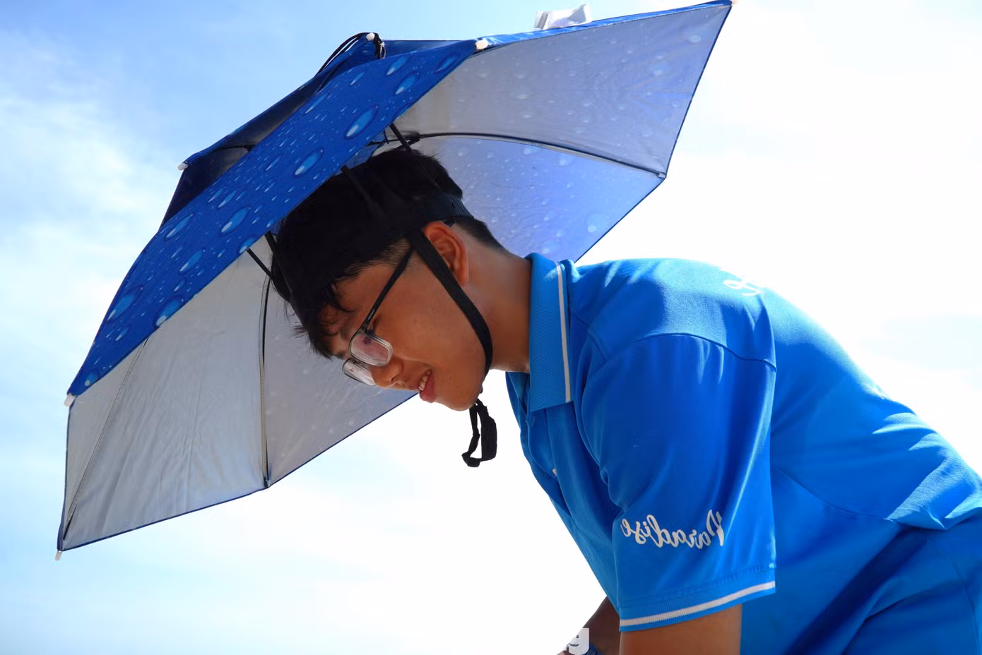 Chống chọi với "chảo lửa" khi làm việc ngoài trời, nhân viên một nhà hàng ven biển phải dùng ô đội đầu thay cho mũ. Theo các nhân viên, do đặc thù phục vụ du khách tắm nắng, ăn uống trên bãi cát nên họ phải ra ngoài trời liên tục. Mọi người phải dùng ô đội đầu để vừa có tán che rộng, vừa tiện lợi khi làm việc.