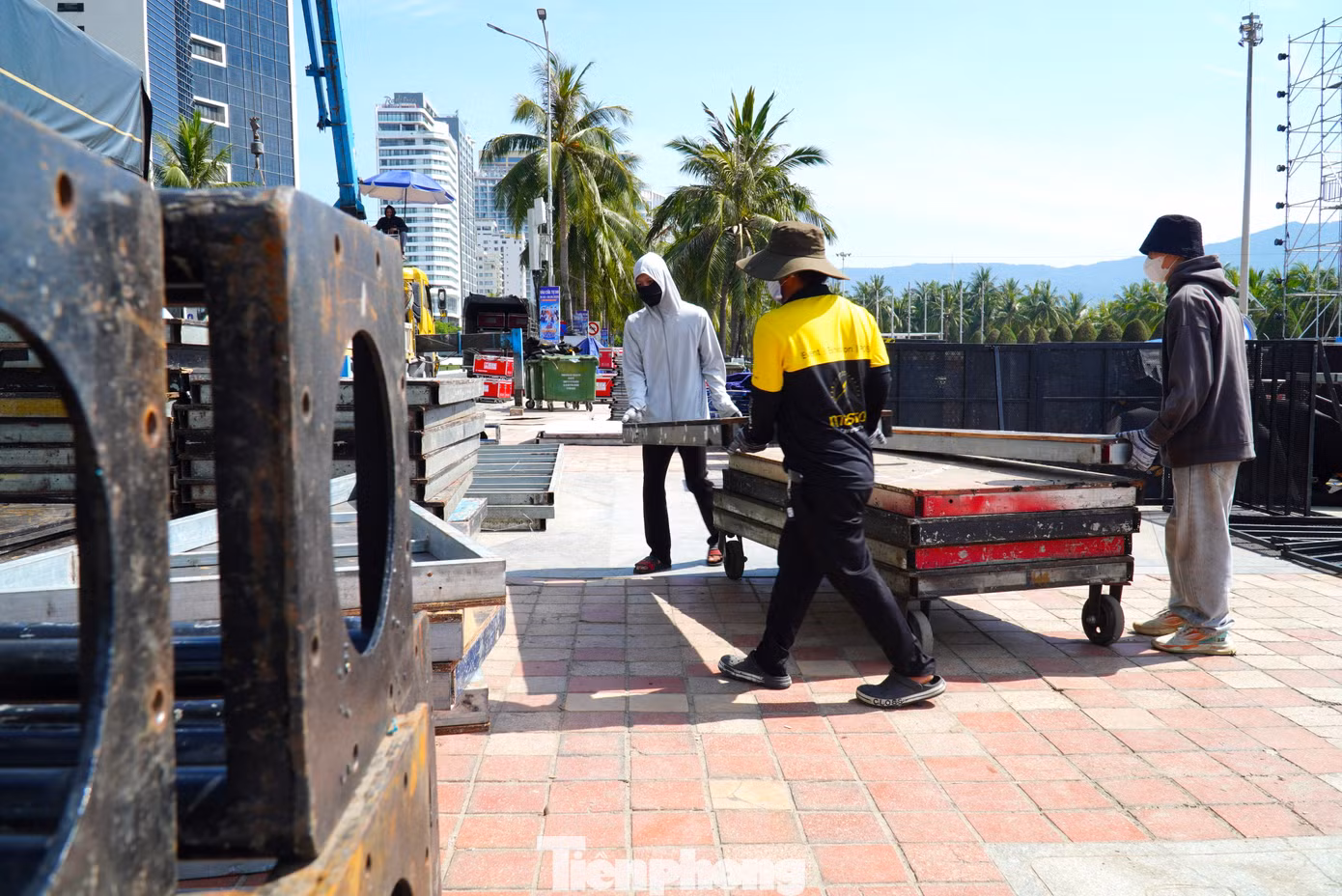 Công nhân lắp dựng sân khấu tại công viên biển Đông đội mũ, trùm kín mặt dưới thời tiết gần 40 độ. Nhiệt độ ngoài trời đo được còn cao hơn.