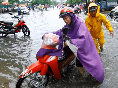 Nhân viên công ty thoát nước đẩy xe giúp người có xe bị chết máy. Ảnh: Ngọc Châu. Nhân viên công ty thoát nước đẩy xe giúp người có xe bị chết máy. Ảnh: ngọc châu