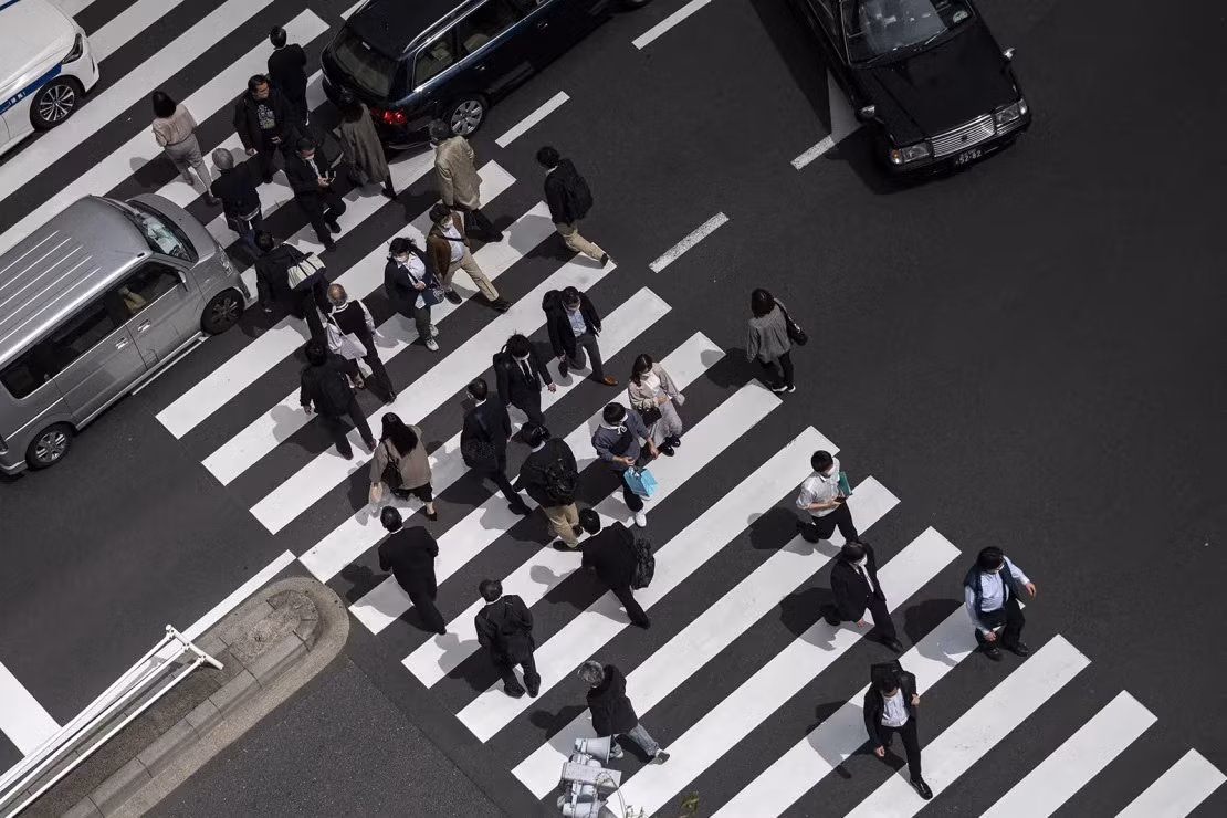 Người đi bộ, bao gồm nhân viên văn phòng băng qua đường ở khu vực Shimbashi của Tokyo vào giờ nghỉ trưa ngày 1 /4/2021. Ảnh: Getty Images. Người đi bộ, bao gồm nhân viên văn phòng băng qua đường ở khu vực Shimbashi của Tokyo vào giờ nghỉ trưa ngày 1 /4/2021. Ảnh: Getty Images.