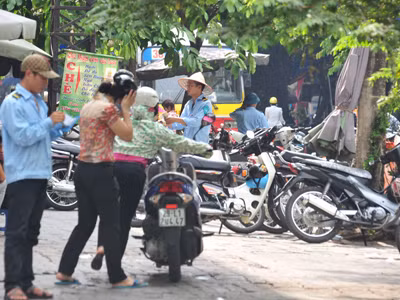 Nhân viên trông xe tại cổng chợ Hôm thu tiền trái quy định. Ảnh: Hoàng Anh Nhân viên trông xe tại cổng chợ Hôm thu tiền trái quy định
