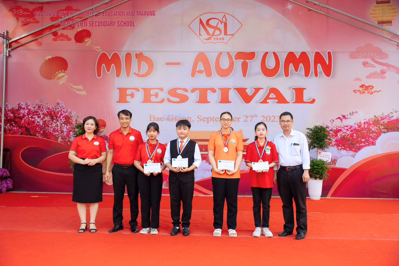 Thầy cô Ban giám hiệu nhà trường chụp hình lưu niệm cùng 4 bạn xuất sắc nhất trong cuộc thi.