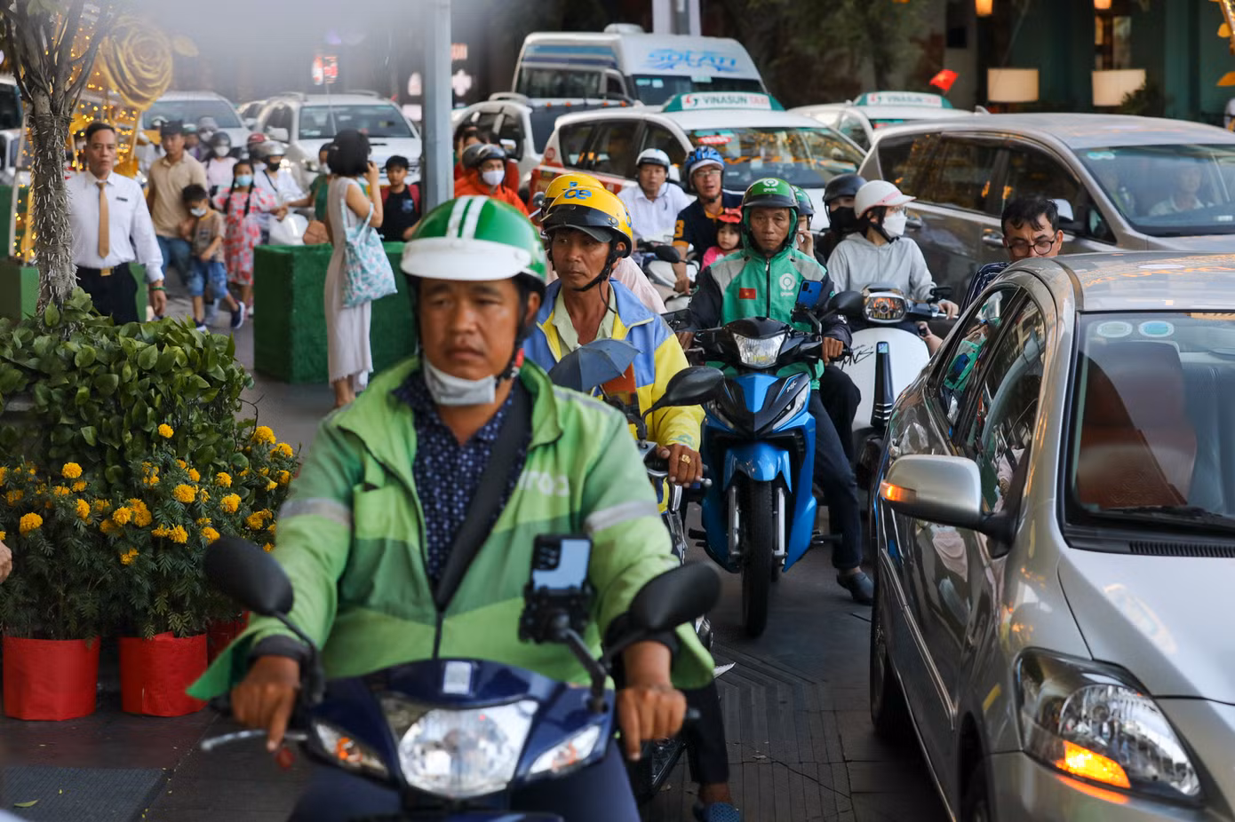 Nhiều người điều khiển xe máy leo lên vỉa hè để thoát khỏi đoạn kẹt.