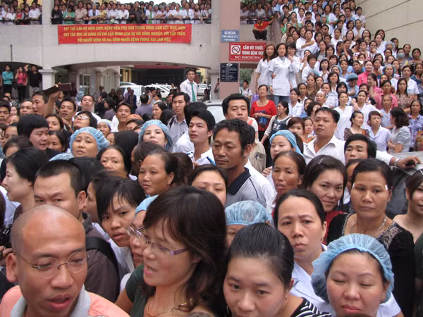 Đông đảo y bác sĩ , các sản phụ, người nhà đổ ra hành lang và sân bệnh viện chờ đón cháu bé trở về. Ảnh: Lãng Phong.