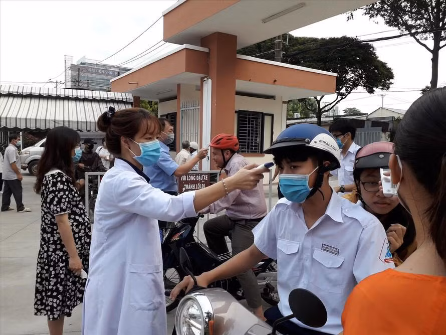 Trường THPT chuyên Nguyễn Hữu Huân đo thân nhiệt cho học sinh trước khi các em vào lớp
