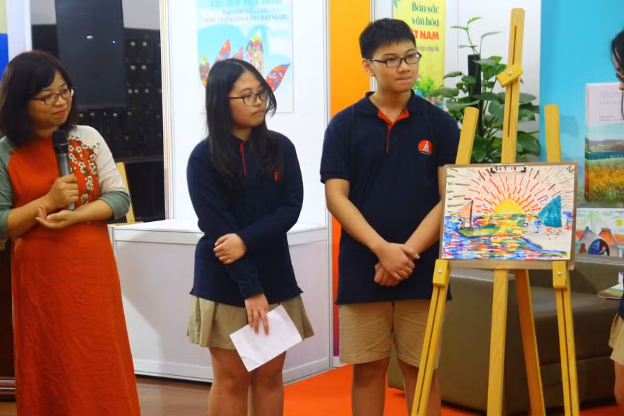 Tiến sĩ Ngữ văn Nguyễn Thị Ngọc Minh (áo dài đỏ) làm giám khảo cho phần game tương tác vẽ minh hoạ truyện "Đoàn thuyền đánh cá" của các bạn học sinh THCS Marie Curie. Ảnh: T.Dương. Tiến sĩ Ngữ văn Nguyễn Thị Ngọc Minh (áo dài đỏ) làm giám khảo cho phần game tương tác vẽ minh hoạ truyện "Đoàn thuyền đánh cá" của các bạn học sinh THCS Marie Curie. Ảnh: T.Dương.