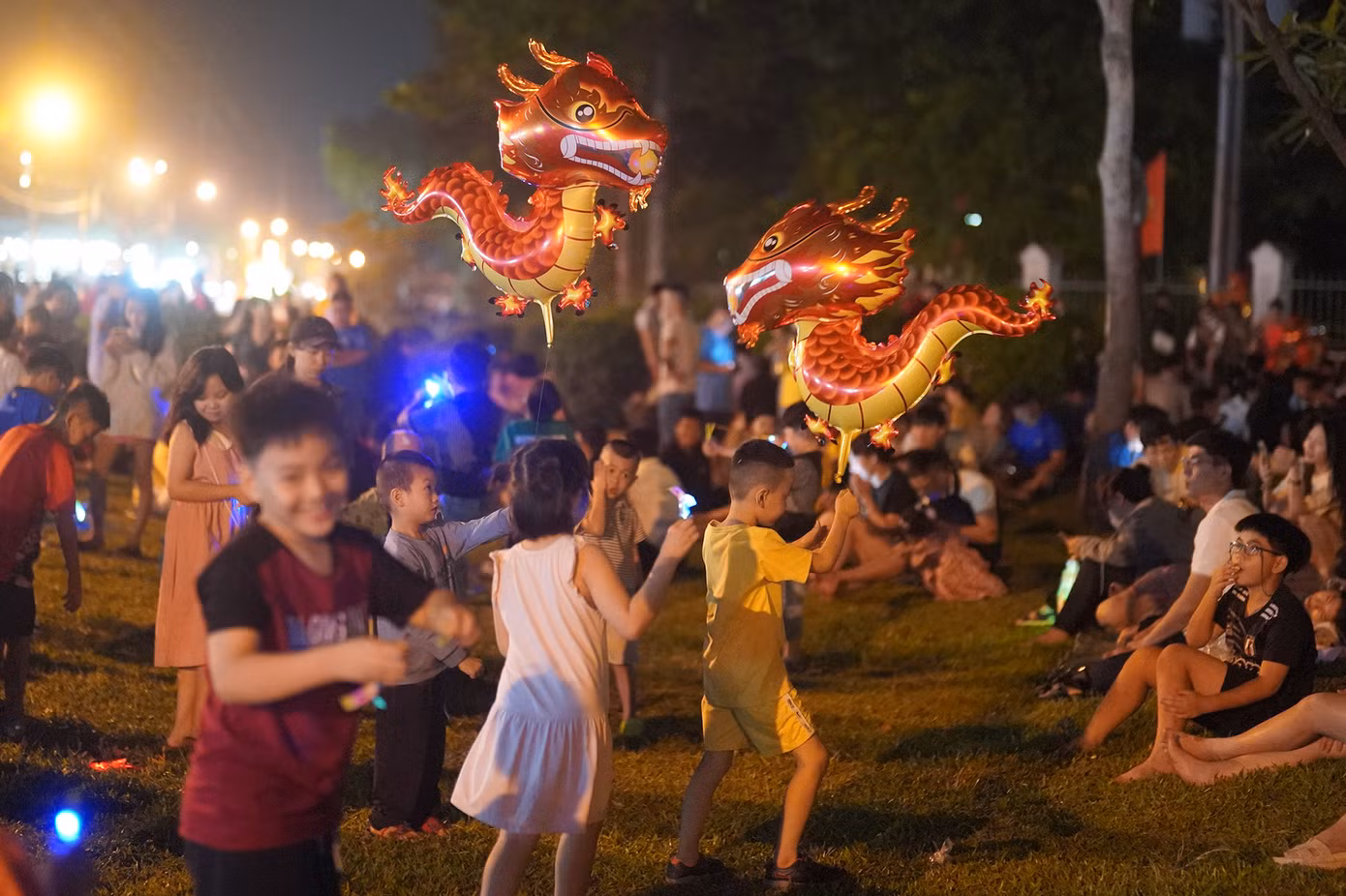 Các em nhỏ thích thú với bóng bay linh vật rồng được bố mẹ mua cho. Các em nhỏ thích thú với bóng bay linh vật rồng được bố mẹ mua cho.