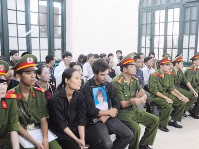Anh Khuất Văn Hiền ôm chặt di ảnh của con gái cũng vợ mặc bộ đồ đen đau đớn trước cái chết của cô con gái nhỏ