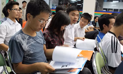 các bạn trẻ chăm chú xem thông tin về các nhà tuyển dụng