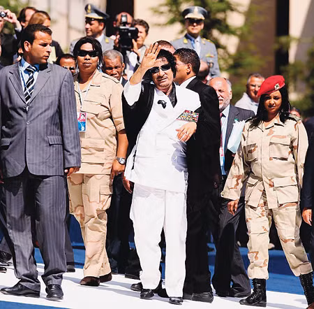 Ông Gadhafi đứng giữa hai nữ vệ sĩ Ảnh: Getty Images. Ông Gadhafi đứng giữa hai nữ vệ sĩ Ảnh: Getty Images