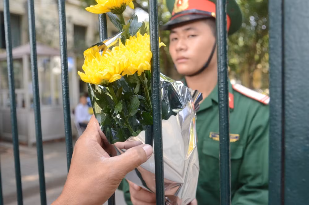 Các anh cảnh vệ liên tục nhận hoa từ người dân đến viếng