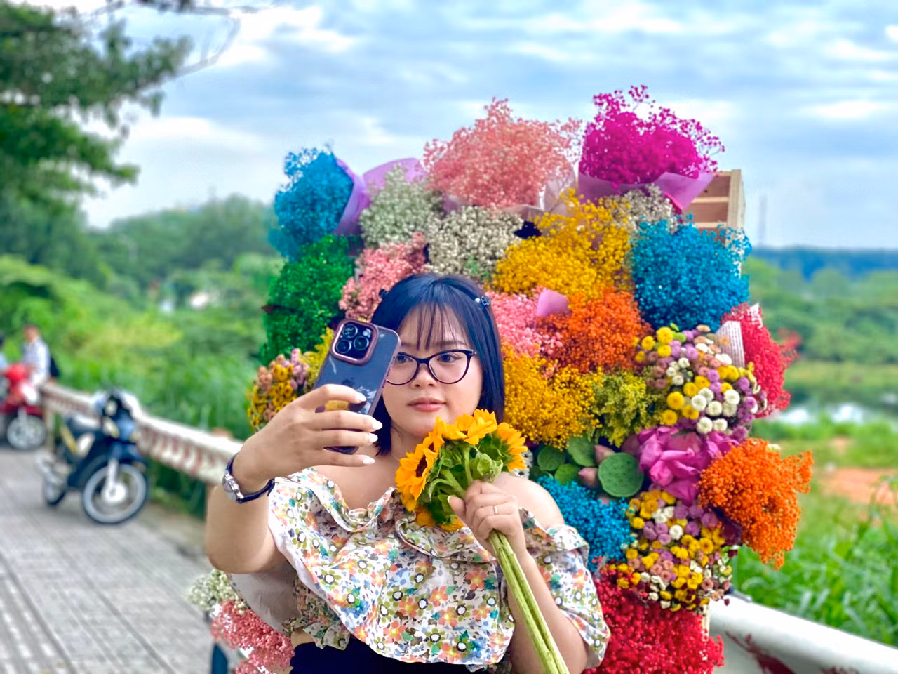 Xiêu lòng trước vẻ đẹp của xe hoa 'chở đầy' Thu Hà Nội, chị Phạm Ngọc (30 tuổi) cùng bạn bè đến 'check-in' cùng tại khu vực Làng Đại học Thủ Đức. “Nơi đây có hồ nước, cây xanh, những trảng cỏ thoáng mát làm mình có cảm giác như đang ở một nơi phong cảnh hữu tình", chị Ngọc nói.