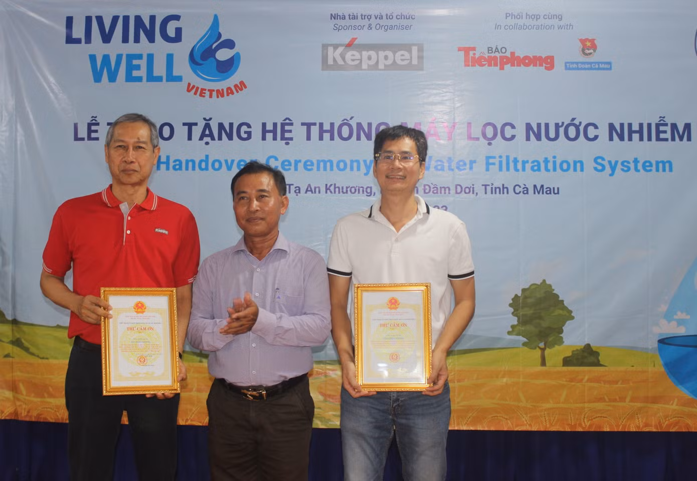 Nhà báo Lý Thành Tâm - Trưởng cơ quan đại diện báo Tiền Phong (bên phải) và ông Adris Bin Isnin - Giám đốc Bộ phận Quản lý Dự án và Bền vững thuộc Bộ phận Bất động sản của Tập đoàn Keppel tại Việt Nam (bên trái) nhận thư cảm ơn từ lãnh đạo UBND xã Tạ An Khương.