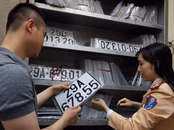 CSGT trao biển kiểm soát mới 5 số cho dân thay biển cũ là 4 số.