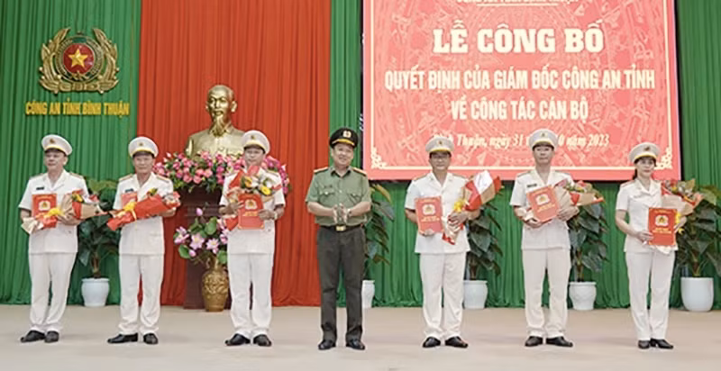 Đại tá Trần Văn Mười, Phó Giám đốc Công an tỉnh trao quyết định, tặng hoa cho sáu sĩ quan công an vừa được bổ nhiệm, điều động. Ảnh Công an Bình Thuận