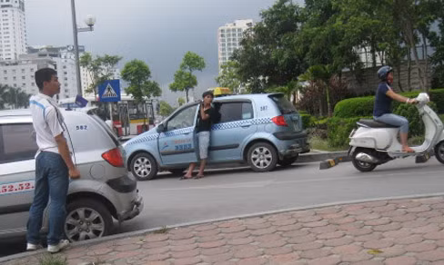 Một lái xe taxi mặt quần lửng, áo phông không cổ. Ảnh: Sỹ Lực