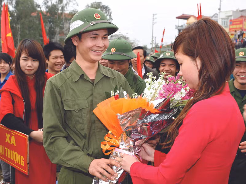 Nữ sinh huyện Thạch Thất (Hà Nội) tặng hoa cho tân binh trước giờ tòng quân