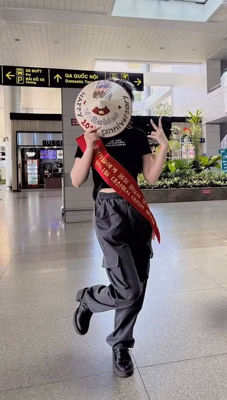 Một bạn fan cực cá tính với chiếc nón lá đáng yêu đại diện cho blog Dear our 2003. Team của các bạn không đến sân bay đón thần tượng được nên bạn fan này đã đại diện. Theo Dear our 2003, chiếc sash này chính là sự hiện diện của cả team (hoặc những ai không thể đến sân bay). Ảnh: Dear our 2003