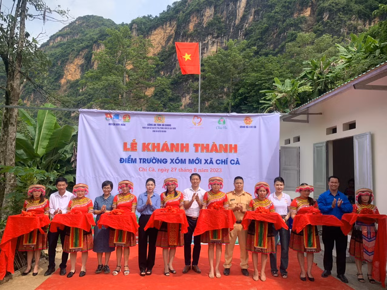 Bà Vũ Thị Hòa – UVBTV Huyện ủy, Phó Chủ tịch thường trực UBND huyện, Đại úy Hoàng Long - Bí thư Chi đoàn Phòng Cảnh sát Giao thông, Phòng QLHC về TTXH Công an tỉnh, anh Lộc Văn Huy – Huyện ủy viên, Bí thư Huyện đoàn, Chủ tịch Hội Đồng đội huyện Xín Mần và đại diện các đơn vị từ thiện cắt băng khánh thành điểm trường Xóm Mới.