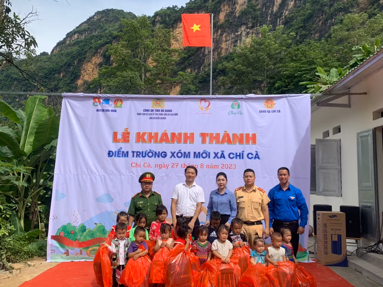 Bà Vũ Thị Hòa – UVBTV Huyện ủy, Phó Chủ tịch thường trực UBND huyện, Đại úy Hoàng Long - Bí thư Chi đoàn Phòng Cảnh sát Giao thông, Phòng QLHC về TTXH Công an tỉnh, anh Lộc Văn Huy – Huyện ủy viên, Bí thư Huyện đoàn, Chủ tịch Hội Đồng đội huyện Xín Mần và đại diện các đơn vị từ thiện cắt băng khánh thành điểm trường Xóm Mới.