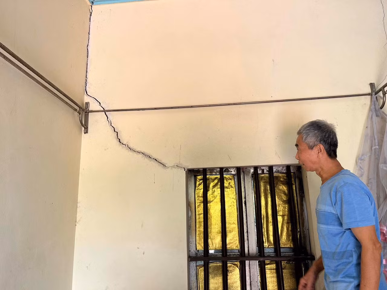 Bà Ngô Văn Phương bất an khi chứng kiến vết nứt trên tường rào ngày càng mở rộng.