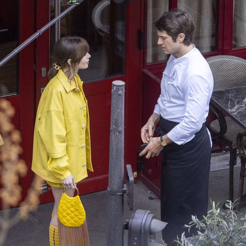 Lily Collins và Lucas Bravo trong một cảnh quay Emily in Paris mùa 4. Lily Collins và Lucas Bravo trong một cảnh quay Emily in Paris mùa 4.