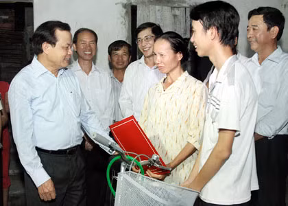 Bí thư Thành ủy Hà Nội Phạm Quang Nghị tặng quà gia đình em Lê Đức Duẩn ở xã Hoàng Long, huyện Phú Xuyên. (Ảnh: Bá Hoạt) 