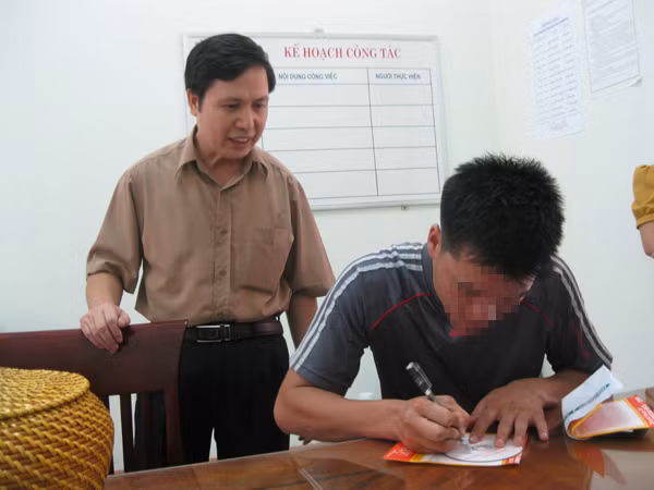 Ông Đinh Thế Cường, Phó Chánh Thanh tra Sở GD&ĐT Bắc Giang hướng dẫn anh Nguyễn Danh Ngọc ký tên lên bìa đĩa dữ liệu trước khi giao nộp cho cơ quan thanh tra Sở GD&ĐT