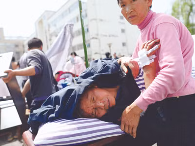 Người dân thẫn thờ nhìn ngôi nhà đổ nát của mình. Ảnh: Reuters.