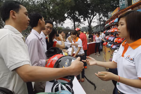 Điểm đổi mũ bảo hiểm trợ giá tại trước cổng công viên Thống Nhất, Hà Nội