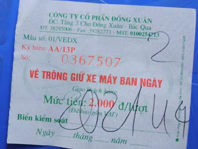 Vé gửi xe vào chợ Đồng Xuân ghi giá 2.000đ/lượt, thực tế thu 5.000đ/lượt. ảnh: Hà Anh. Vé gửi xe vào chợ Đồng Xuân ghi giá 2.000đ/lượt, thực tế thu 5.000đ/lượt (ảnh nhỏ) - ảnh: Hà Anh