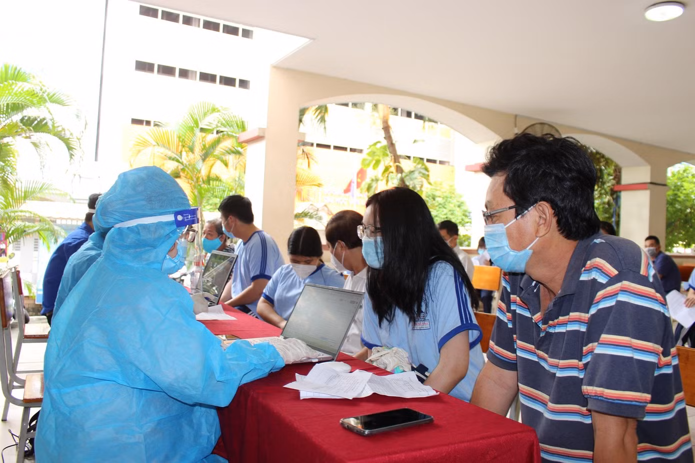 Cha mẹ và người giám hộ hỗ trợ cho học sinh trong quá trình khám sàng lọc trước khi tiêm chủng.
