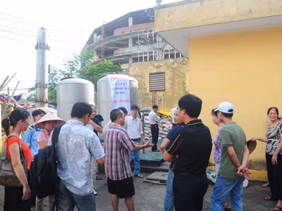 Người dân cùng Công ty Cổ phần đầu tư bất động sản Hà Nội lập biên bản và niêm phong mẫu nước tại trạm bơm để đưa đi xử lý. Ảnh: Tuấn Nguyễn