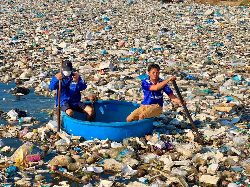 Người dân đưa thuyền thúng tham gia vớt rác trên đầm nước mặn Sa Huỳnh.