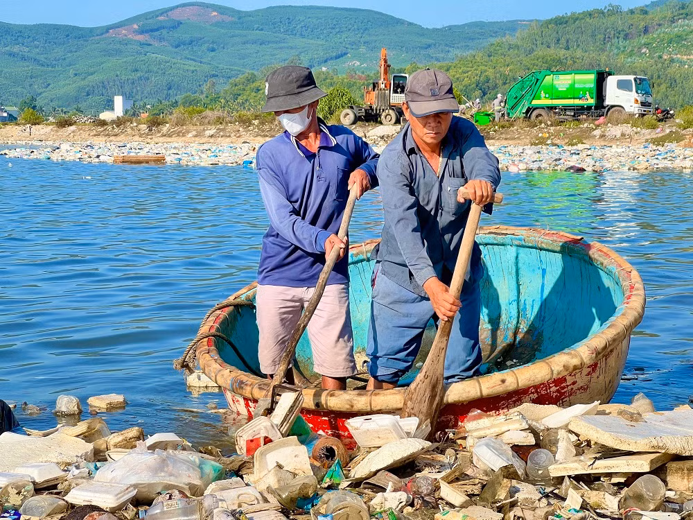 Người dân đưa thuyền thúng tham gia vớt rác trên đầm nước mặn Sa Huỳnh.