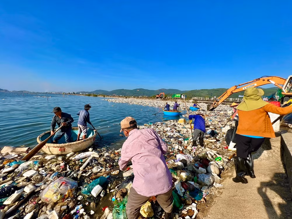 Người dân đưa thuyền thúng tham gia vớt rác trên đầm nước mặn Sa Huỳnh.