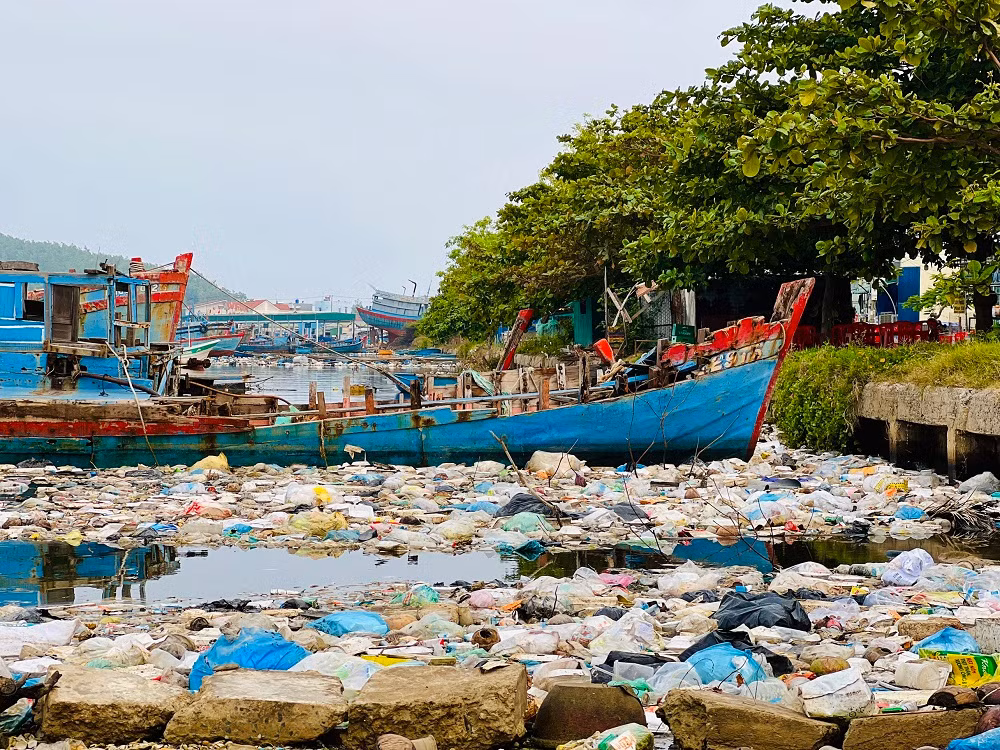Xác của những con tàu, rác thải và cả nước thải từ cảng cá, nước thải sinh hoạt của người dân chưa qua xử lý, đã tạo nên những vùng nước đen ngòm, bốc mùi hôi thối nồng nặc, gây bức xúc cho người dân tại cảng cá (Ảnh: Nguyễn Ngọc)