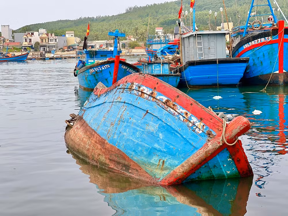 Chị Đoàn Thị Chung (trú phường Phổ Thạnh, thị xã Đức Phổ) cho hay, ngoài xác tàu và rác thải, quanh khu vực cảng cá Sa Huỳnh còn bị ô nhiễm bởi một số cơ sở thu mua và chế biến hải sản xả nước thải trực tiếp chưa qua xử lý. Những hôm trời nắng, nước ở khu vực này đen ngòm. Nhiều ngư dân bị nổi ngứa sau khi lặn xuống nước để kiểm tra thân tàu hoặc kéo tàu lên bờ để sửa. (Ảnh: Nguyễn Ngọc)