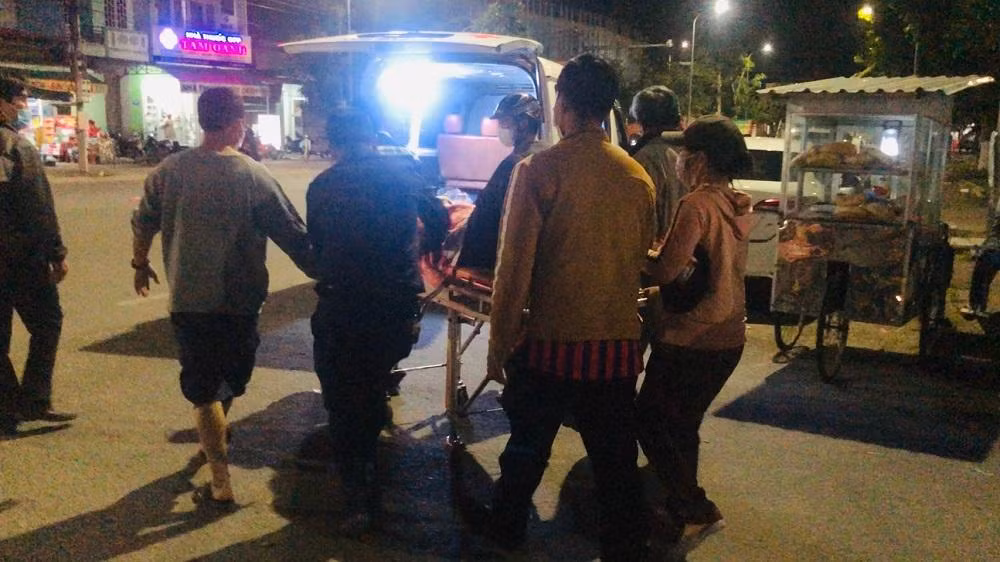 Người nhà dùng băng ca đẩy bệnh nhân ra ngoài đường hơn 50m để đưa lên xe cứu thương. Ảnh: M.H