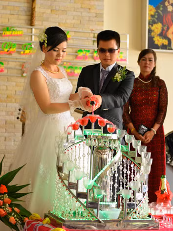 Cô dâu Bích Trầm cầm tay chú rể Xuân Long trong nghi thức rót rượu hồng