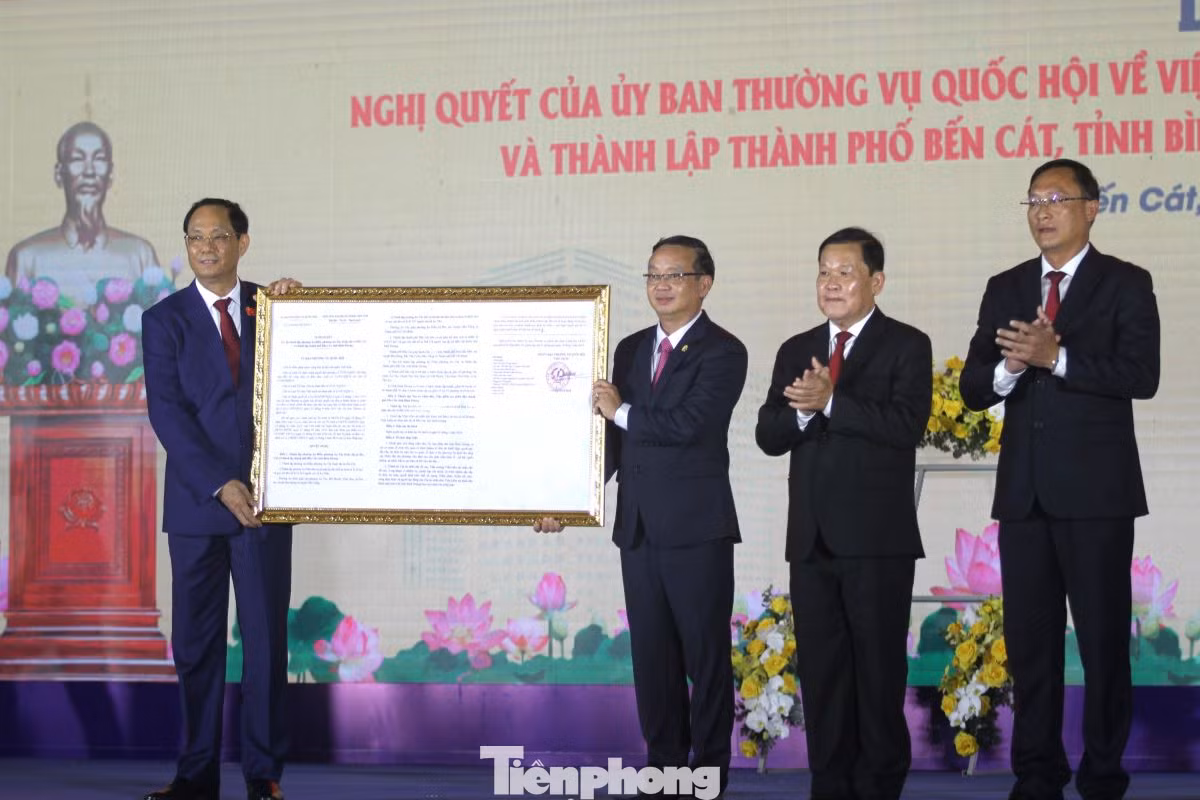 Phó Chủ tịch Quốc hội Trần Quang Phương (bìa trái) trao Nghị quyết về việc thành lập thành phố Bến Cát