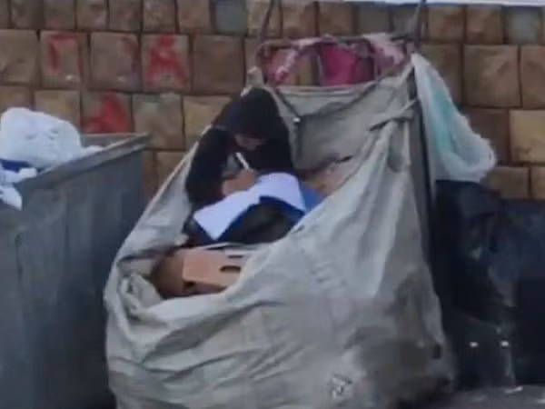 Halime Cuma ngồi học trên đống phế liệu.