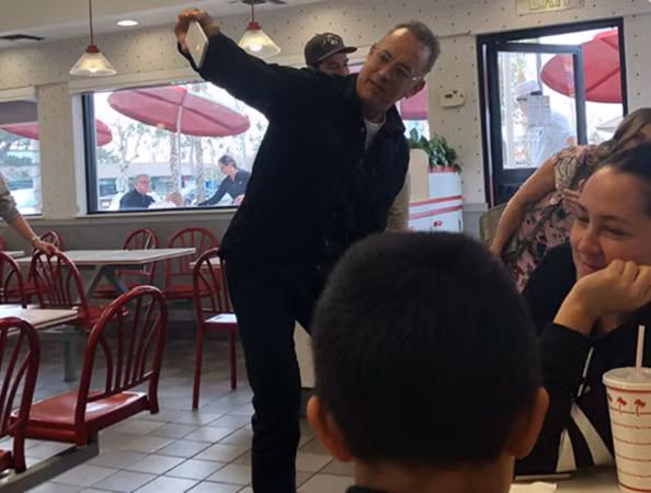 Tom Hanks cầm điện thoại chụp ảnh cùng các thực khách.